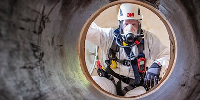 Pracovník s respirátorem a přilbou 3M
