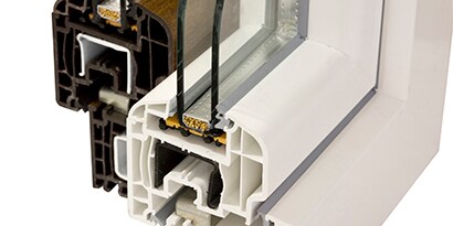 Průřez vinylem, neboli tvrdým PVC, na kterém je vidět okenní rám spojený se sklem pomocí lepidla 3M
